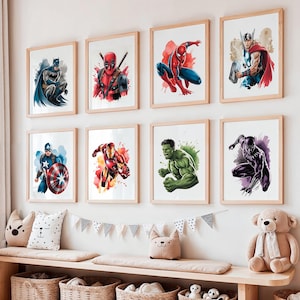 May include: A set of framed superhero art prints. The prints showcase characters including Batman, Deadpool, Spider-Man, Thor, Captain America, Iron Man, Hulk, and Black Panther. Each print has a watercolour style with bright colours, set in a light wood frame.