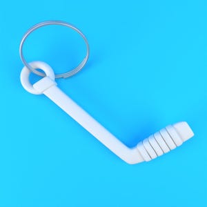 May include: A white hockey stick keychain featuring a smooth, angled shaft and a textured blade with five distinct horizontal ridges. The stick is attached to a standard circular silver metal split ring for keys, presented against a solid blue background.