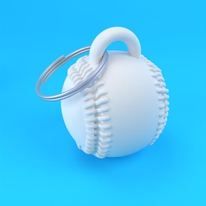 Puede incluir: Un llavero de béisbol blanco con un llavero plateado. El béisbol tiene costuras detalladas y un lazo para el llavero. El fondo es de color azul claro sólido.