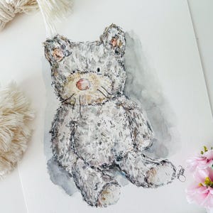 Könnte beinhalten: Ein Aquarellbild eines grauen Teddybären mit einer rosa Nase. Der Bär sitzt auf einem grauen Hintergrund.