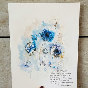 May include: A watercolor painting of blue flowers with a quote by Elizabeth Gilbert that reads "Be Brave. Without bravery, you will never know the world as richly as it longs to be known. Without bravery, your life will remain small - far smaller than you probably wanted your life to be."