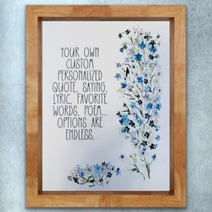 Puede incluir: Una impresión enmarcada con fondo blanco y texto negro que dice "YOUR OWN CUSTOM PERSONALIZED QUOTE, SAYING, LYRIC, FAVORITE WORDS, POEM... OPTIONS ARE ENDLESS." La impresión presenta una pintura de acuarela de flores azules y blancas.