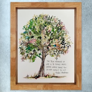 May include: A framed watercolor painting of a tree with green and brown foliage. The text reads: The true meaning of life is to plant trees under whose shade you do not expect to sit. - Nelson Henderson. The frame is made of light-colored wood.