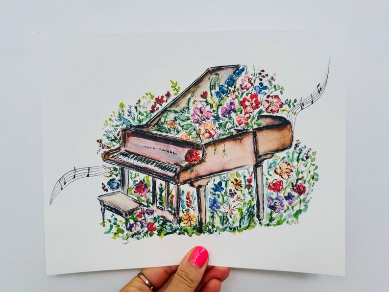 Peut inclure: Une peinture &agrave; l'aquarelle d'un piano &agrave; queue avec des fleurs qui poussent dessus. Le piano est brun et blanc, et les fleurs sont de diff&eacute;rentes couleurs, notamment rose, rouge, jaune et bleu. La peinture est sur un fond blanc.