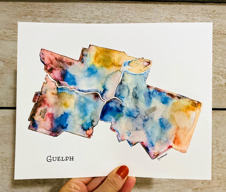K&ouml;nnte beinhalten: Aquarellmalerei der Stadt Guelph, Ontario, Kanada. Die Karte ist in Blaut&ouml;nen, Rosa, Gelb und Orange gemalt. Der Stadtname "Guelph" ist unten auf der Karte in Schwarz geschrieben.