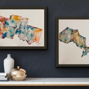 K&ouml;nnte beinhalten: Zwei gerahmte Aquarellbilder der kanadischen Provinz Ontario. Das erste Bild zeigt das Gro&szlig;raum Toronto, w&auml;hrend das zweite Bild die gesamte Provinz zeigt. Beide Bilder sind in Blaut&ouml;nen, Gr&uuml;nt&ouml;nen und Braunt&ouml;nen gehalten.