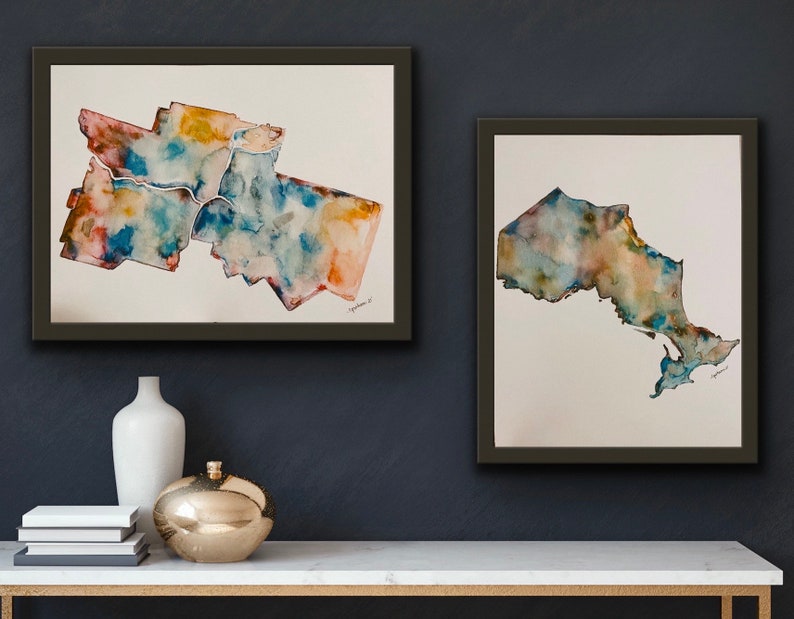 K&ouml;nnte beinhalten: Zwei gerahmte Aquarellbilder der kanadischen Provinz Ontario. Das erste Bild zeigt das Gro&szlig;raum Toronto, w&auml;hrend das zweite Bild die gesamte Provinz zeigt. Beide Bilder sind in Blaut&ouml;nen, Gr&uuml;nt&ouml;nen und Braunt&ouml;nen gehalten.