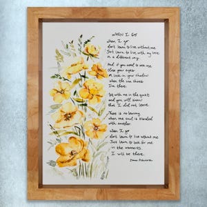 Pode incluir: Impressão de arte em aquarela em uma moldura de madeira clara. A obra apresenta flores amarelas e texto manuscrito de um poema intitulado "When I Go" de Donna Ashworth. O arranjo floral está no lado esquerdo.