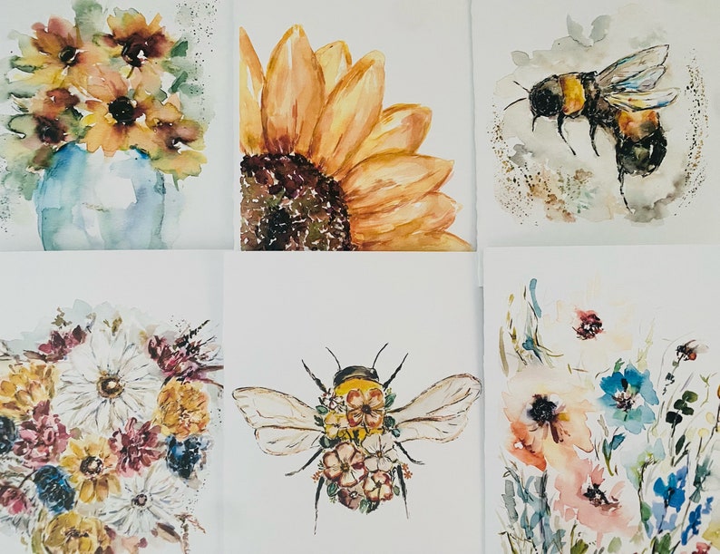 Puede incluir: Pinturas a la acuarela de arreglos florales e insectos. La obra de arte incluye un girasol, una abeja y ramos de flores en tonos amarillos, naranjas, azules y rosas. Las pinturas est&aacute;n sobre un fondo blanco.