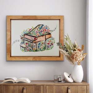 Peut inclure: Une peinture &agrave; l'aquarelle d'un piano &agrave; queue avec des fleurs qui poussent dessus. Le piano est brun et les fleurs sont color&eacute;es. La peinture est encadr&eacute;e dans un cadre en bois.