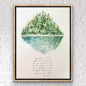 Op de afbeelding: Waterverf schilderij van een bos dat wordt weerspiegeld in een meer met een citaat uit de Bijbel, Johannes 16:33, "Dit heb ik u gezegd, opdat u in mij vrede zult hebben. In de wereld zult u verdrukking hebben, maar wees getroost, Ik heb de wereld overwonnen."