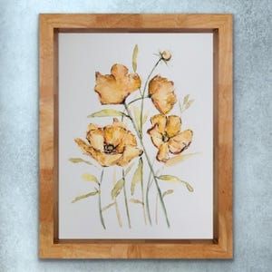 Könnte beinhalten: Aquarellmalerei von orangefarbenen Blumen mit grünen Blättern und Stängeln, vor einem weißen Hintergrund. Das Kunstwerk ist in einem hellbraunen Holzrahmen gerahmt. Das florale Kunstwerk ist ein dekorativer Gegenstand.