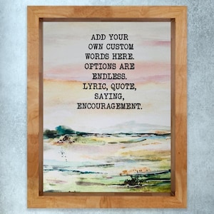 May include: A framed watercolor painting with a landscape scene in shades of green, yellow, and pink. The artwork features the text: "ADD YOUR OWN CUSTOM WORDS HERE. OPTIONS ARE ENDLESS. LYRIC, QUOTE, SAYING, ENCOURAGEMENT."