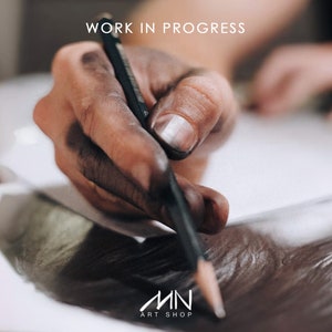 May include: A hand covered in black graphite draws on a white sheet of paper with a black pencil. The text "WORK IN PROGRESS" is visible at the top of the image. The text "MN ART SHOP" is visible at the bottom of the image.