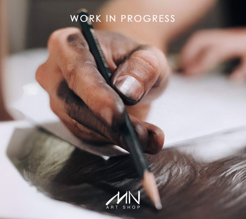 May include: A hand covered in black graphite draws on a white sheet of paper with a black pencil. The text "WORK IN PROGRESS" is visible at the top of the image. The text "MN ART SHOP" is visible at the bottom of the image.