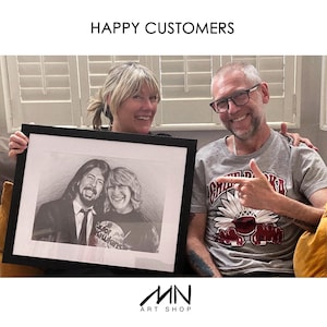 May include: A framed black and white pencil portrait of two people. The portrait is held by a woman and a man, both smiling. The text "HAPPY CUSTOMERS" is at the top. The art shop logo is at the bottom.