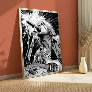 May include: A black and white framed wall art print featuring a stylized illustration of a musician singing into a microphone while playing an electric guitar. The artwork includes a guitar effects pedal and dynamic splash patterns in the background.