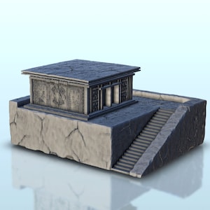 May include: A gray stone building with a flat roof and a set of stairs leading up to it. The building has a carved design on the front and is set on a platform with a cracked surface.