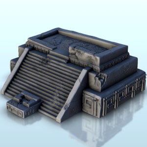 May include: A gray stone pyramid with a flat top and steps leading up to it. The pyramid is decorated with intricate carvings and appears to be weathered and aged.