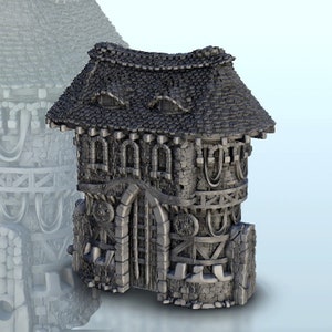 May include: A detailed miniature model of a stone building with a thatched roof, featuring a large arched doorway and multiple windows. The building has a rustic, medieval aesthetic, with intricate details like wooden beams and decorative carvings.