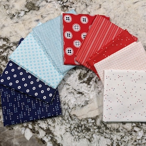 May include: A collection of fabric squares in red, white, and blue with various patterns, including polka dots, stripes, and geometric designs.