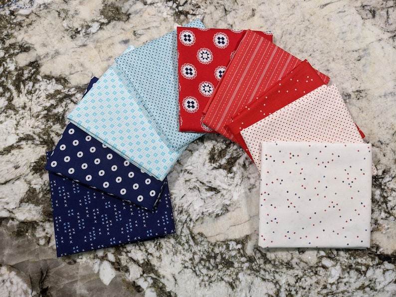 May include: A collection of fabric squares in red, white, and blue with various patterns, including polka dots, stripes, and geometric designs.