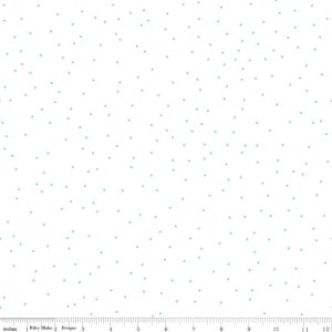 May include: White fabric with a scattered pattern of small, light blue dots. The fabric is marked with a ruler in inches.