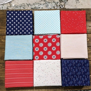 May include: Nine fabric squares in various red, white, and blue patterns. The patterns include polka dots, stripes, and geometric designs.
