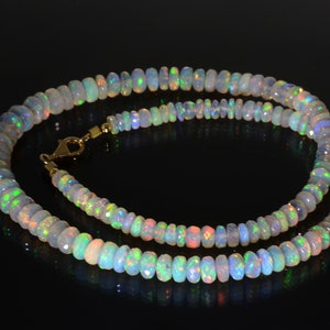 May include: A necklace made of iridescent opal beads with a gold clasp.