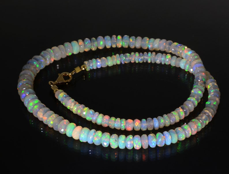 May include: A necklace made of iridescent opal beads with a gold clasp.