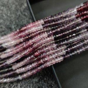 May include: A strand of pink and purple gemstone beads. The beads are faceted and have a slightly irregular shape. The beads are strung on a clear thread.