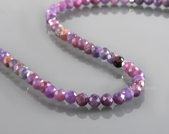 Könnte beinhalten: Eine Kette aus facettierten, runden violetten und rötlich-pinken Perlen, die in einer geschwungenen Linie angeordnet sind. Die Perlen variieren in der Farbintensität und enthalten kleine silberfarbene Zwischenperlen. Der Text Minedbeads ist sichtbar.