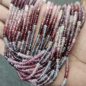 May include: A strand of pink, red, and white gemstone beads. The beads are faceted and have a slightly irregular shape. The strand is approximately 18 inches long.