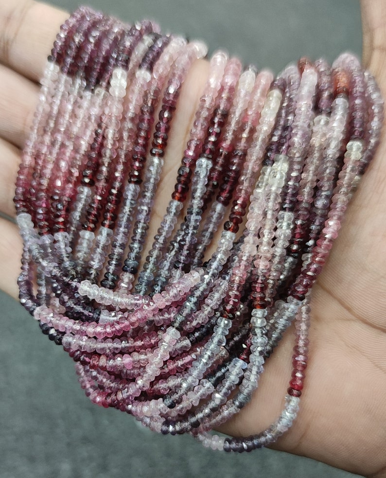 May include: A strand of pink, red, and white gemstone beads. The beads are faceted and have a slightly irregular shape. The strand is approximately 18 inches long.