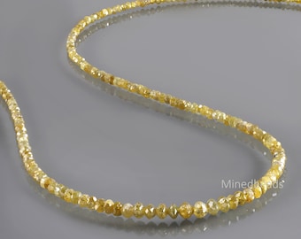 May include: A long strand of small, faceted yellow diamond beads arranged in a curved line. The beads exhibit varying shades of translucent yellow and gold, with a reflective surface. The text Minedbeads is visible in white.