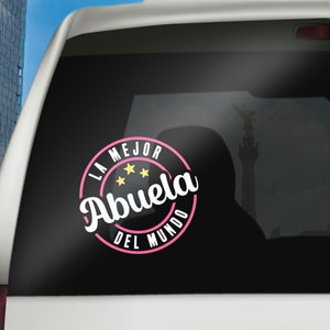 May include: A pink and white circle sticker with the text "La Mejor Abuela Del Mundo" and three yellow stars. The sticker is on a black background.