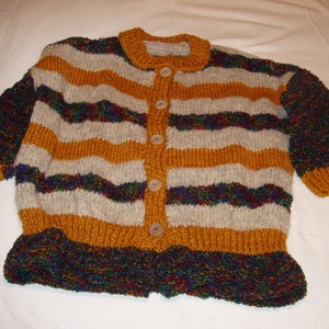 Könnte beinhalten: Ein gestreifter Cardigan mit Knöpfen. Der Pullover ist aus weichem, strukturiertem Garn in Braun-, Beige- und Blautönen gefertigt.