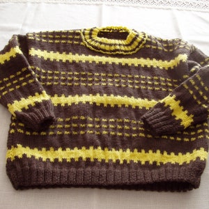 Könnte beinhalten: Ein gestrickter Pullover mit braunen und gelben Streifen und einem hohen Kragen.
