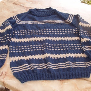 Può includere: Un maglione di lana blu e bianco a righe con collo rotondo.