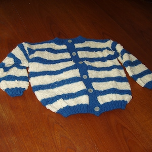 Peut inclure: Un cardigan en tricot rayé bleu et blanc avec des boutons.