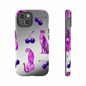 May include: A phone case with a repeating pattern of purple cheetahs and dark purple cherries on a gradient gray background. The case has a black border and camera housing.