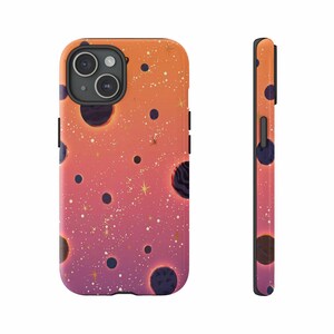 May include: A phone case with a vibrant space-themed design. The case features a gradient of orange, pink, and purple with scattered dark blue planets, gold stars, and white speckles. The case is shown from the front and side.