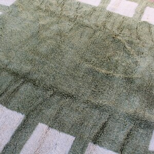 May include: A green shag rug with a white geometric pattern. The rug has a soft, plush texture.