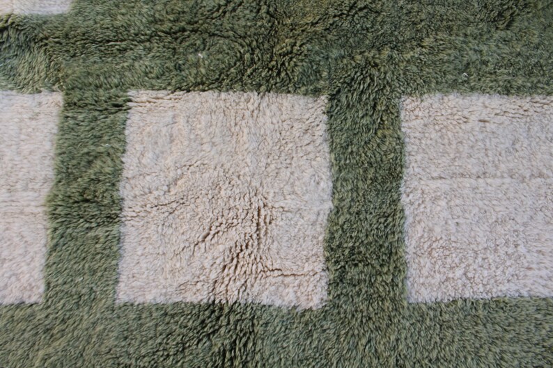 May include: A close-up of a green and white shag rug with a checkered pattern. The rug has a soft, fluffy texture.