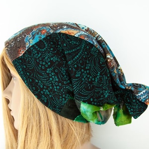 May include: A patterned head covering in brown, teal, and black. The head covering features a paisley design and is made from various fabrics. This fashion accessory has a unique design. The head covering is a fashion accessory.