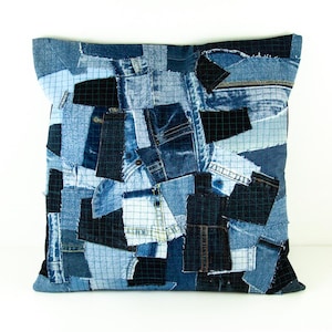 Peut inclure: Coussin carré en patchwork de denim dans diverses nuances de bleu. Le coussin est composé de morceaux de denim recyclés, créant une surface texturée unique. Le design intègre différents délavages et textures de denim, offrant une esthétique rustique et artisanale.