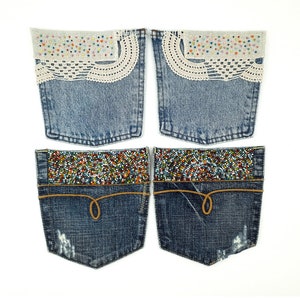 May include: Four denim pockets with different embellishments. Two pockets have a white crocheted trim with colorful beads. The other two pockets have a brown leather trim and a row of colorful beads.