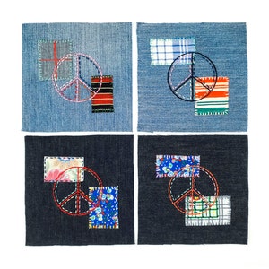 Może przedstawiać: Cztery kwadratowe naszywki z tkaniny z haftowanymi znakami pokoju i kolorowymi akcentami z tkaniny. Dwie naszywki są dżinsowe, a dwie granatowe. Znaki pokoju są wyszywane czerwoną i czarną nicią.