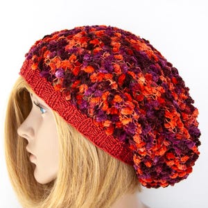 May include: A red, orange, and purple knitted beanie with a fuzzy texture.