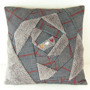May include: Square cushion with a grey plaid pattern and red lines. The centre has a spiral design with grey faux fur and three small heart-shaped embellishments. A home decor item, the cushion measures approximately 40cm x 40cm.
